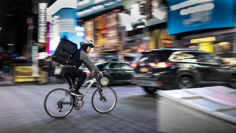 Same-Day vs. Next-Day: Was erwartet der Kunde 2026 wirklich? man riding bicycle near vehicles