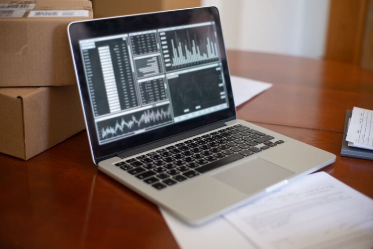 KI in der Disposition – Laptop mit Datenanalysen neben Versandkartons