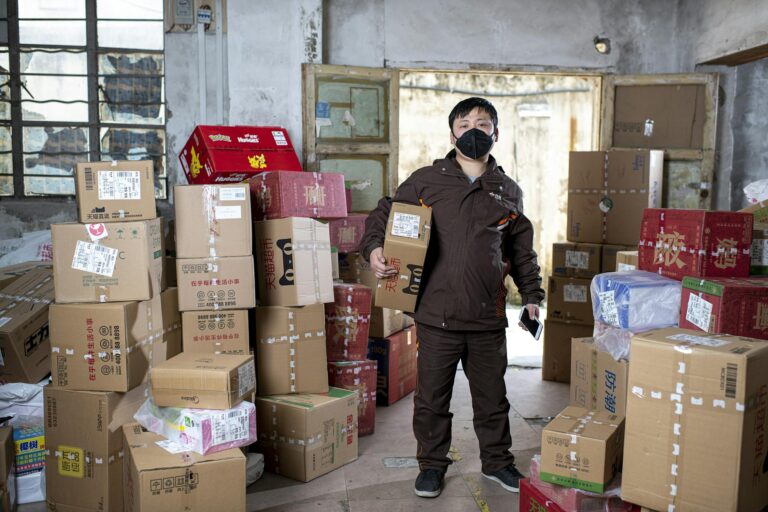 Cainiao Tracking – Mitarbeiter im Lager scannt Paket mit Smartphone