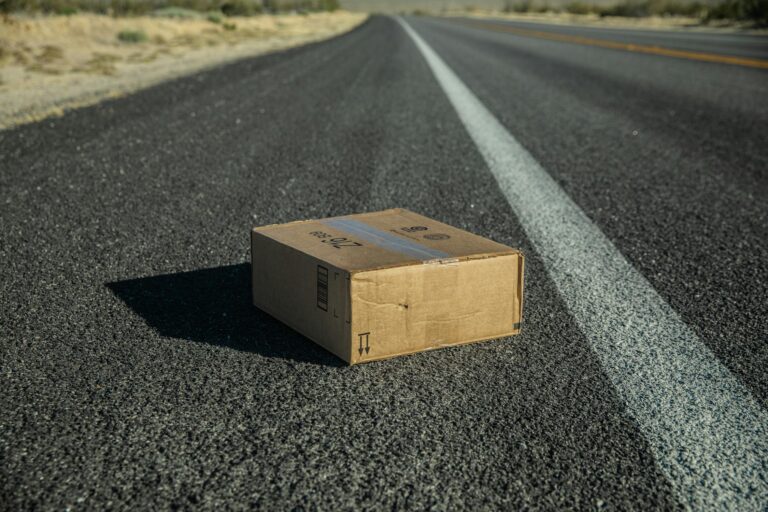 DHL Paket verschwunden – Kartonpaket liegt verloren auf einer Straße
