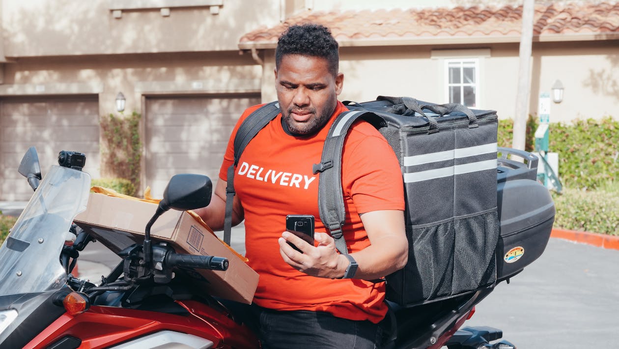 SEUR Tracking – Kurier mit Motorrad und Smartphone bei der Sendungsverfolgung