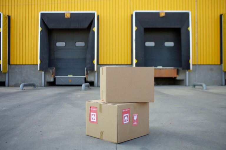DHL Versteigerung: Wie du an günstige Restposten kommst DHL Versteigerung – Kartons vor den Laderampen eines Lagers