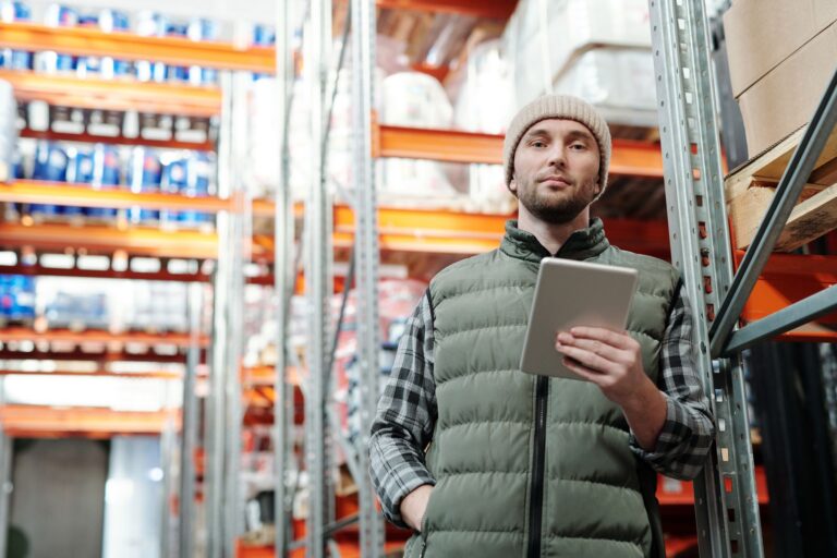 Künstliche Intelligenz in der Logistik: Strategische Einsatzbereiche und Implementierungstipps Künstliche Intelligenz in der Logistik – Lagerleiter mit Tablet zwischen Hochregalen