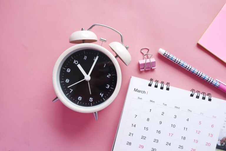 Digitale Arbeitszeiterfassung in der Logistik – Wecker und Kalender auf dem Schreibtisch