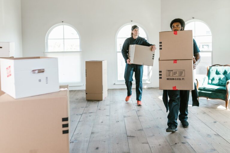 Firmenumzug ohne Betriebsstillstand – Umzugshelfer tragen Kartons