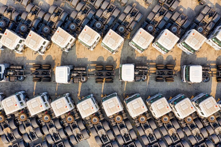 Lkw-Terminal planen: Checkliste für Bodenmarkierungen, Zufahrtszonen und Normen Lkw-Terminal planen – Luftaufnahme geparkter Lkw in Reihen auf einem Depot