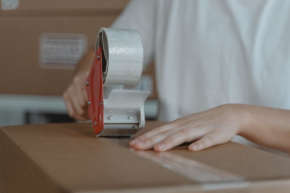 Paket nach Kanada, Karton wird mit Klebeband versandfertig verschlossen