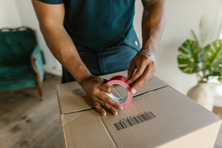 Paket nach S&uuml;dafrika, Person verpackt einen Karton versandfertig