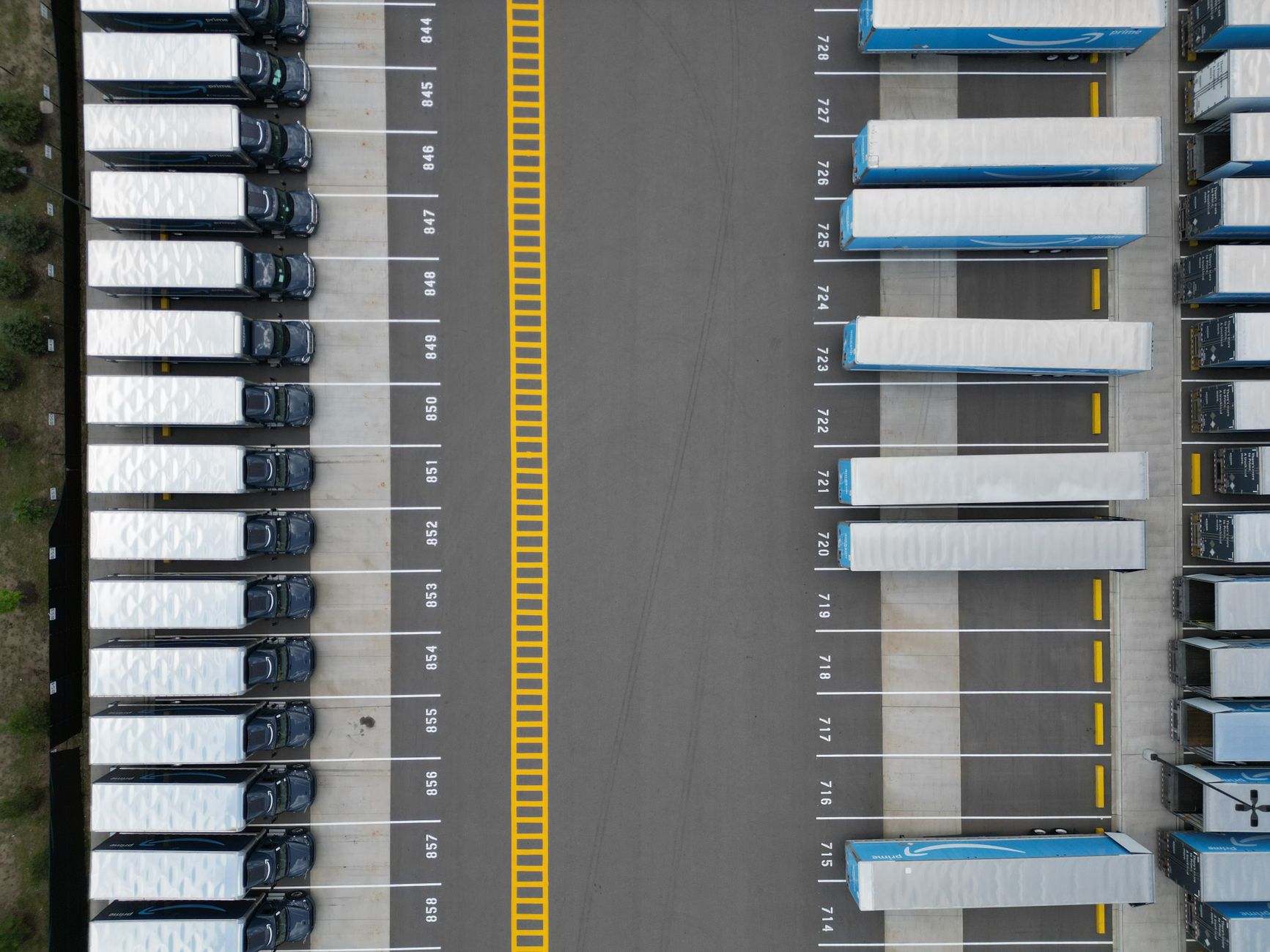 Milkrun – Luftaufnahme eines Logistikparks mit Lkw an den Verladetoren