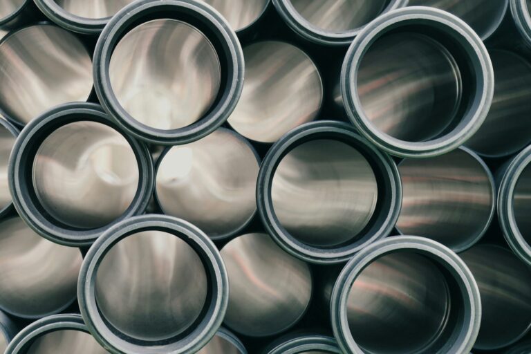 Was sind Axialkompensatoren? Ein technischer Leitfaden für Rohrleitungssysteme a pile of metal pipes stacked on top of each other