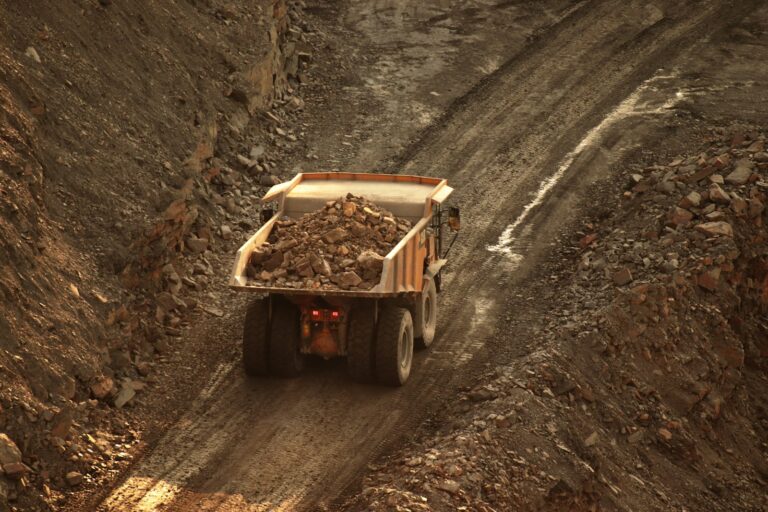 Gebrauchte Muldenkipper – beladener Muldenkipper auf einer Baustellenpiste