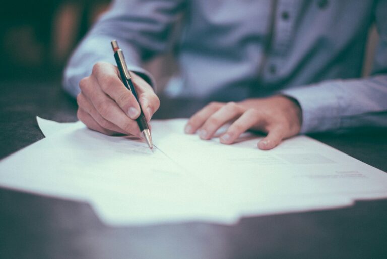 Kautionsversicherung abschließen: Direkt beim Versicherer oder über einen Krediversicherungsmakler? man writing on paper
