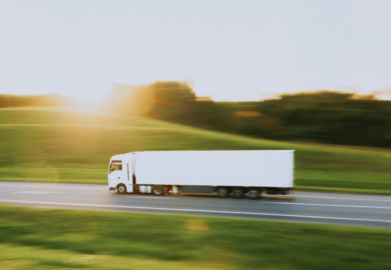 Kommunikation mit internationalen LKW-Fahrern a white semi truck driving down a rural road